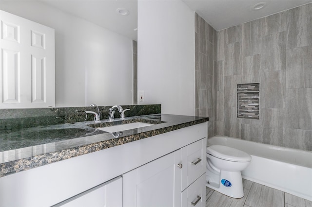 full bathroom featuring toilet, tiled shower / bath combo, and vanity