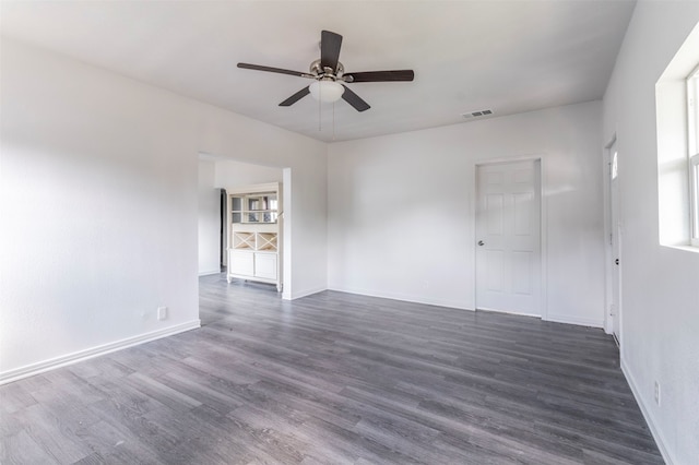 empty room with dark wood-type flooring and ceiling fan