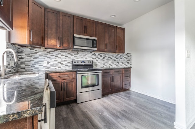 kitchen featuring dark wood-type flooring, stainless steel appliances, sink, and tasteful backsplash