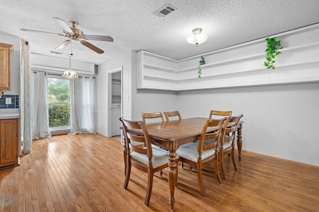 dining room featuring light wood-type flooring, a textured ceiling, and ceiling fan