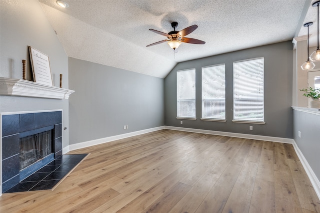 living room with wood-type flooring, a textured ceiling, and lofted ceiling