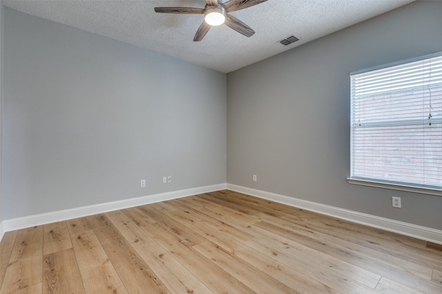 spare room with ceiling fan, light hardwood / wood-style flooring, and a textured ceiling