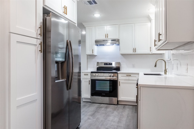 kitchen with light wood-type flooring, appliances with stainless steel finishes, sink, and white cabinets