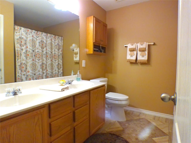 bathroom with tile patterned flooring, vanity, and toilet