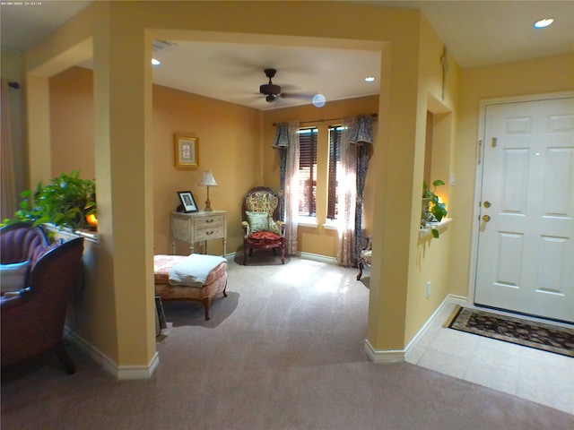 entryway with ceiling fan and carpet flooring