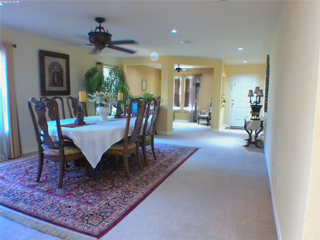 carpeted dining area with ceiling fan