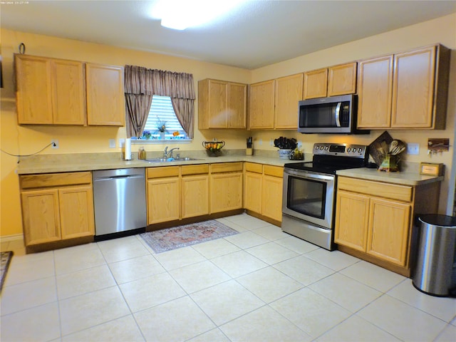 kitchen featuring light tile patterned floors, light brown cabinets, stainless steel appliances, and sink