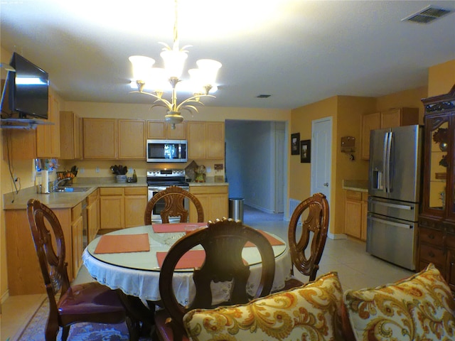 tiled dining area featuring sink and a chandelier