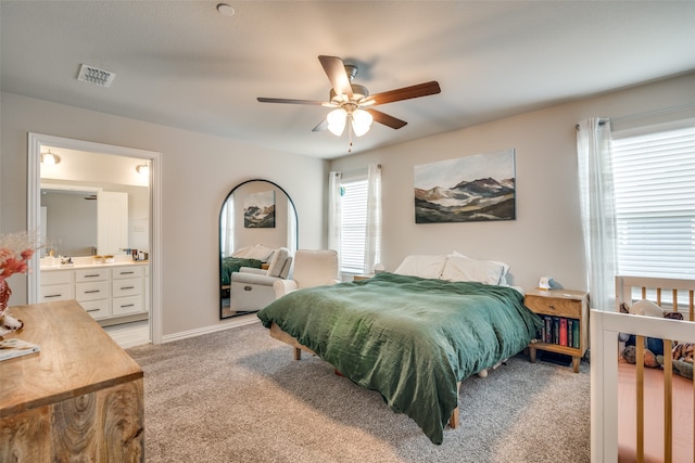 carpeted bedroom with ceiling fan and ensuite bathroom