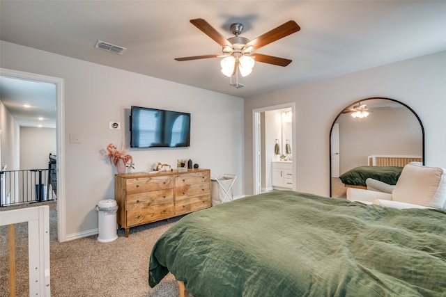 bedroom with ceiling fan, light carpet, and ensuite bath