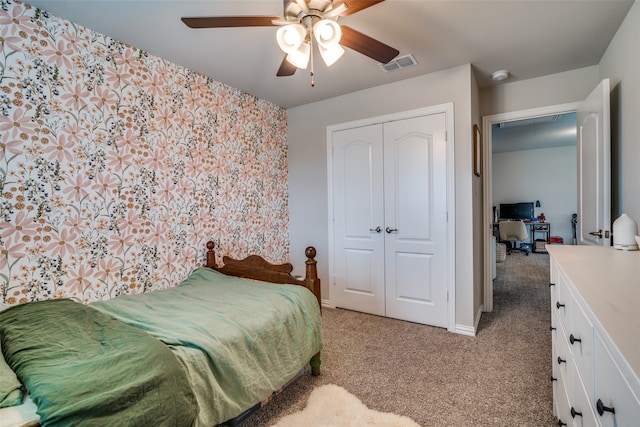 bedroom with light colored carpet, ceiling fan, and a closet