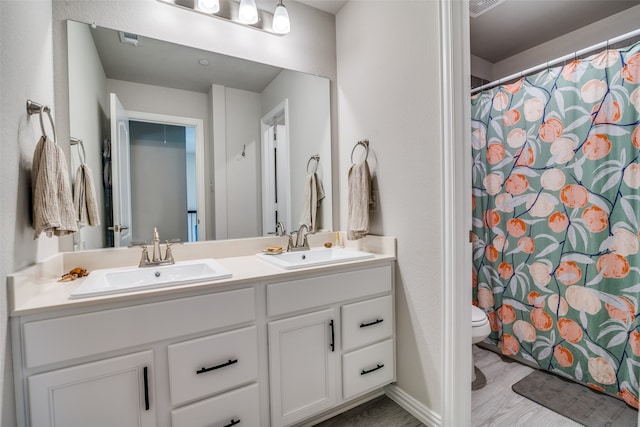 bathroom with vanity, toilet, hardwood / wood-style floors, and curtained shower