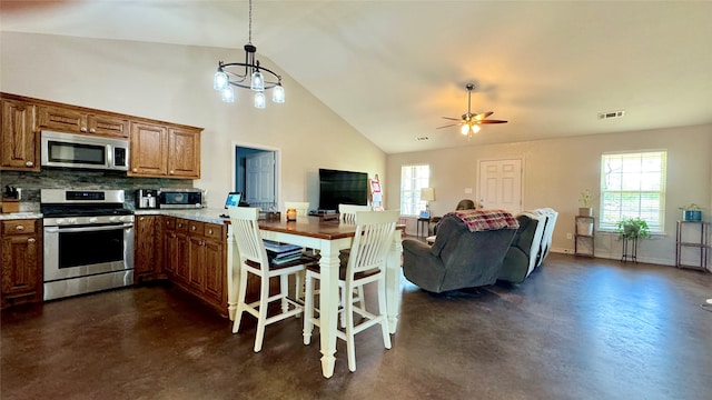 kitchen featuring stainless steel appliances, a healthy amount of sunlight, backsplash, and hanging light fixtures