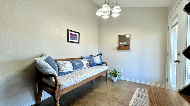 sitting room featuring a chandelier and concrete flooring