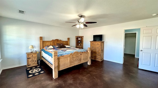 bedroom featuring ceiling fan, a closet, and a walk in closet