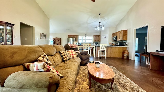 living room featuring high vaulted ceiling and a notable chandelier