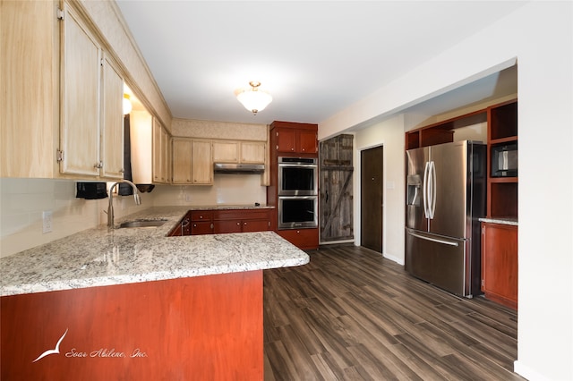 kitchen with dark hardwood / wood-style floors, kitchen peninsula, sink, and appliances with stainless steel finishes