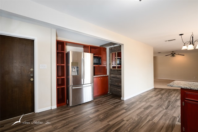 kitchen featuring ceiling fan with notable chandelier, dark hardwood / wood-style floors, light stone counters, stainless steel fridge with ice dispenser, and black microwave