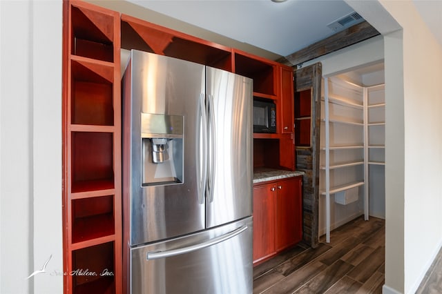 kitchen featuring stone countertops, stainless steel fridge with ice dispenser, and dark wood-type flooring