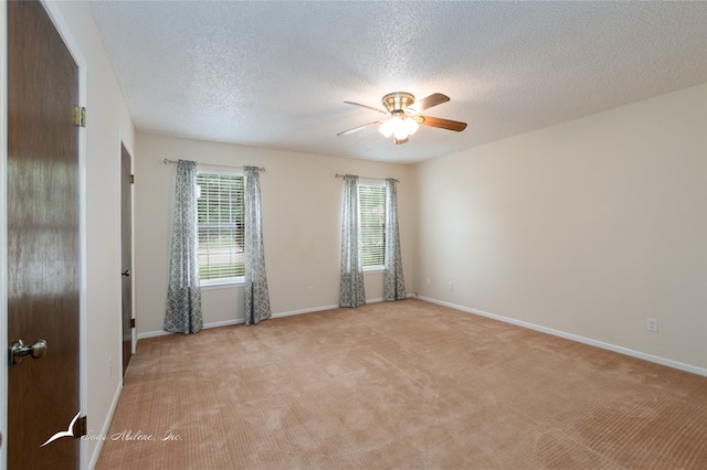 carpeted spare room featuring ceiling fan and a textured ceiling