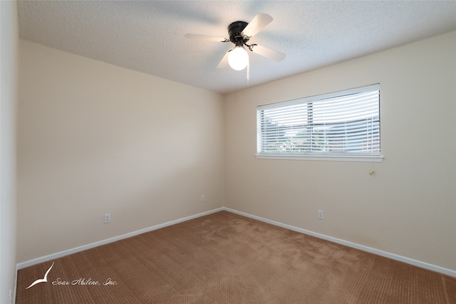 carpeted empty room with ceiling fan and a textured ceiling