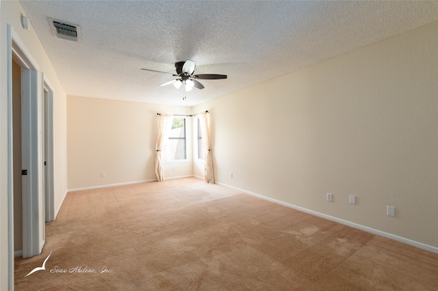 carpeted spare room featuring a textured ceiling and ceiling fan