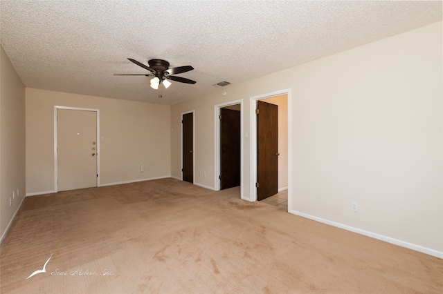 carpeted empty room with ceiling fan and a textured ceiling