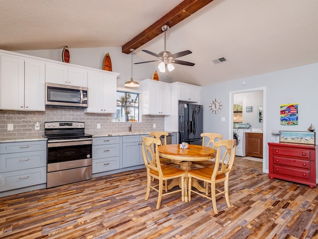 kitchen with white cabinets, lofted ceiling with beams, stainless steel appliances, wood-type flooring, and ceiling fan