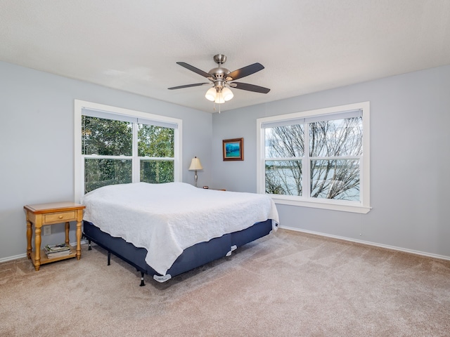 bedroom featuring light colored carpet and ceiling fan