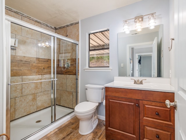 bathroom with vanity, toilet, hardwood / wood-style flooring, and walk in shower