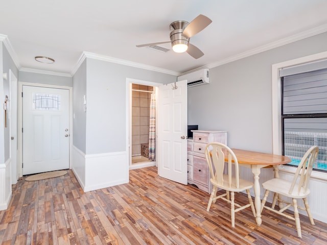 dining room featuring a wall mounted AC, light hardwood / wood-style floors, ornamental molding, a barn door, and ceiling fan