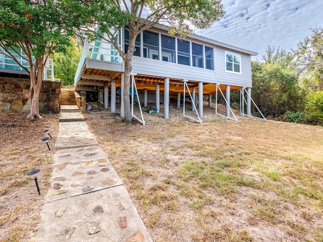 rear view of property featuring a sunroom