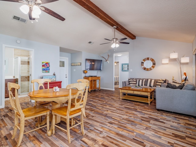 dining area featuring lofted ceiling with beams, dark hardwood / wood-style flooring, ceiling fan, and a textured ceiling