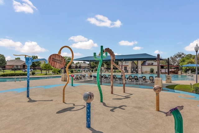 view of play area featuring a community pool and a patio area