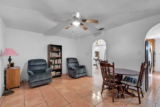 tiled dining room featuring a textured ceiling and ceiling fan