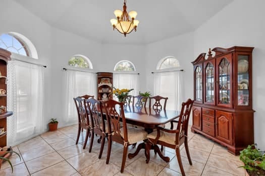 tiled dining room with a notable chandelier