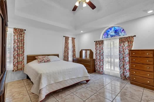 bedroom featuring ceiling fan and a tray ceiling