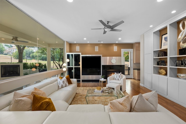 living room with plenty of natural light, ceiling fan, and light hardwood / wood-style flooring