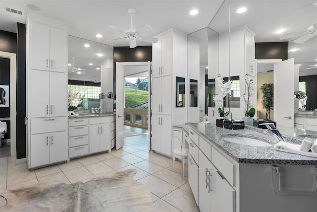 kitchen with white cabinets, ceiling fan, a wealth of natural light, and light tile patterned floors