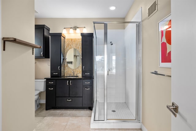 bathroom with tile patterned flooring, toilet, a shower with door, and vanity