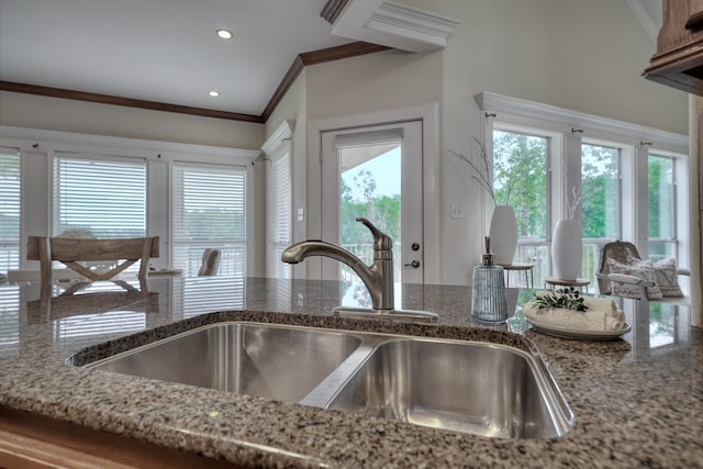 kitchen featuring crown molding, a wealth of natural light, sink, and stone counters