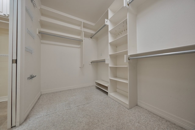 walk in closet featuring light carpet