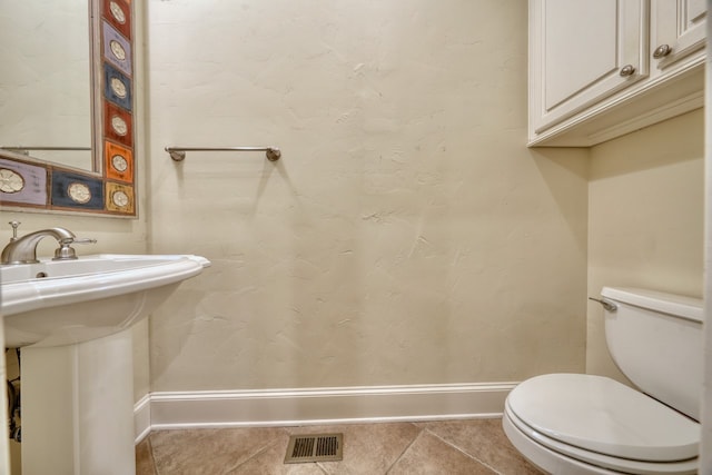 bathroom with toilet and tile patterned floors