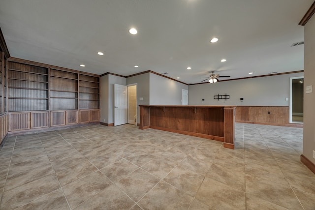 kitchen featuring built in shelves, ornamental molding, wood walls, kitchen peninsula, and ceiling fan