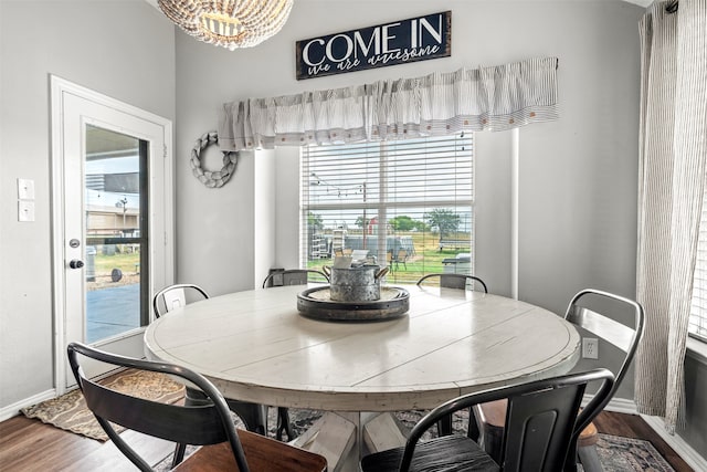 dining space with hardwood / wood-style floors and a chandelier