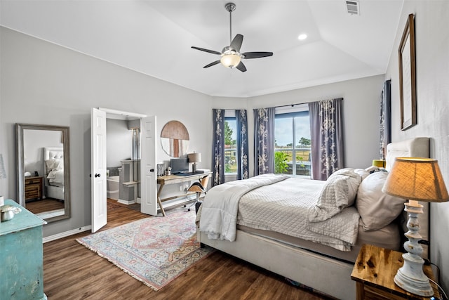 bedroom featuring ensuite bathroom, a raised ceiling, vaulted ceiling, ceiling fan, and dark wood-type flooring