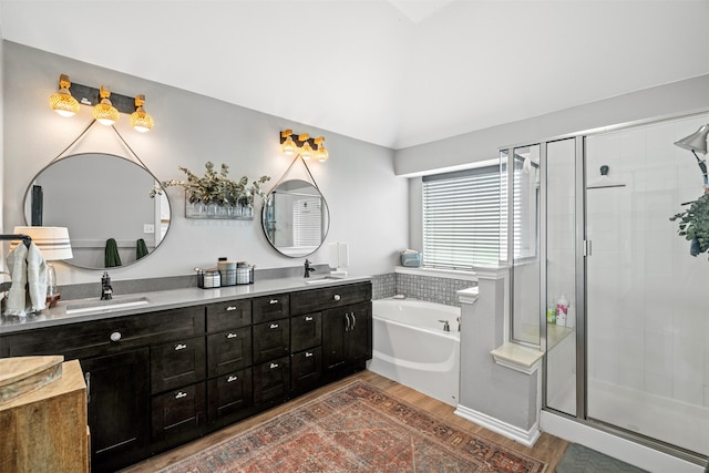 bathroom with vanity, wood-type flooring, plus walk in shower, and vaulted ceiling