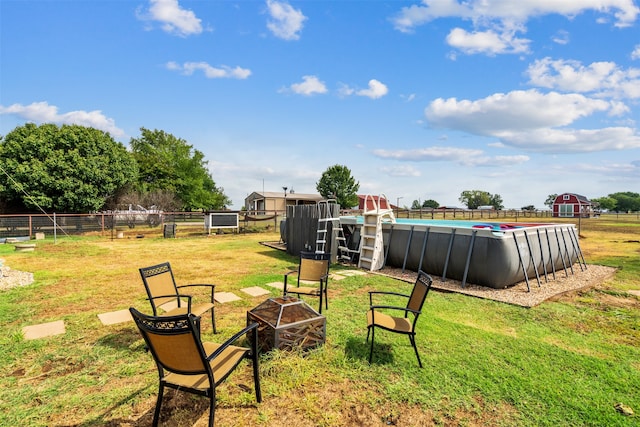 view of yard with a fenced in pool and an outdoor fire pit