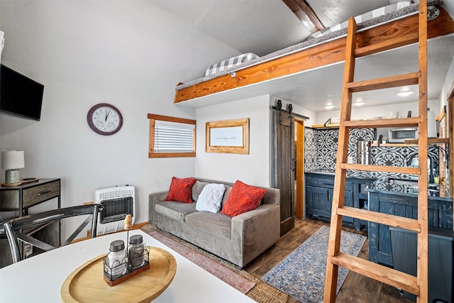 living room with heating unit, wood-type flooring, and a barn door