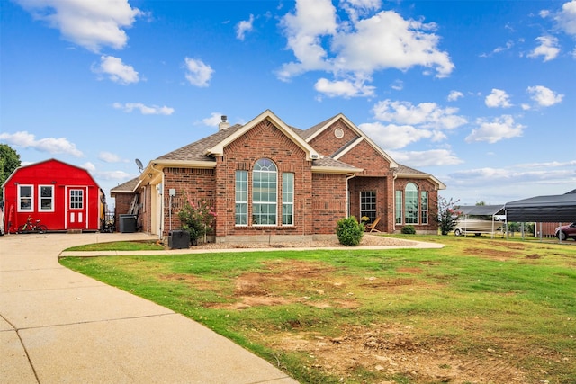 view of front of home with central air condition unit, a shed, and a front yard